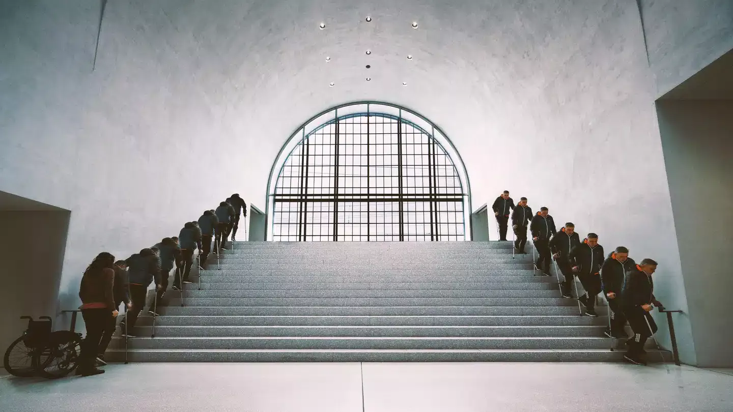 People ascending and descending a modern staircase indoors.